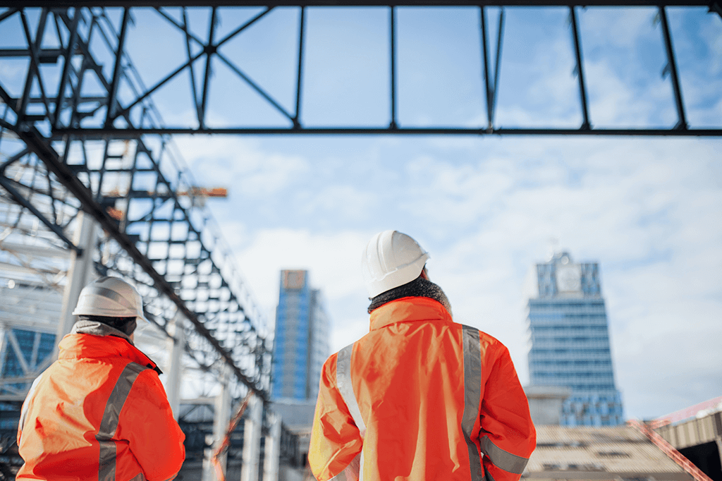 Rear view of engineers or workers standing outdoors on a construction site